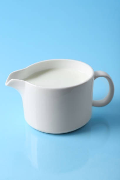 istock Jug of fresh milk on light blue background 1942815263