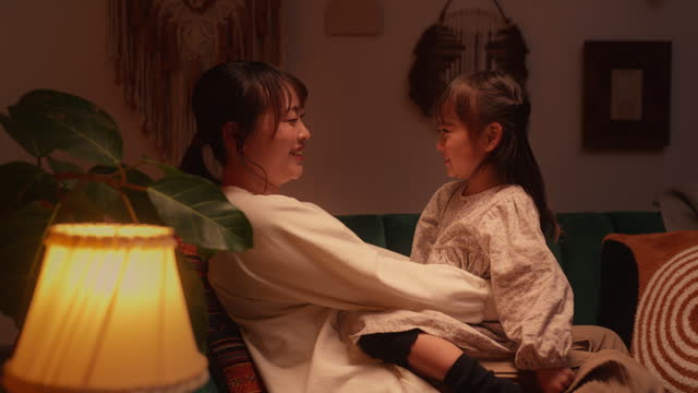 Mother spending time with her daughter in the living room at home