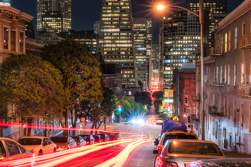 Light trails created by passing cars on the street in downtown San Francisco at night.