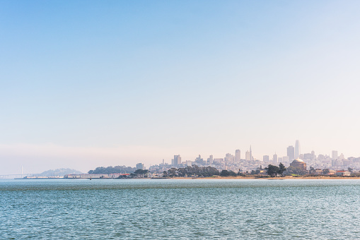 A view of San Francisco's cityscape on a clear, sunny day, as seen in the distance from near the Golden Gate Bridge.