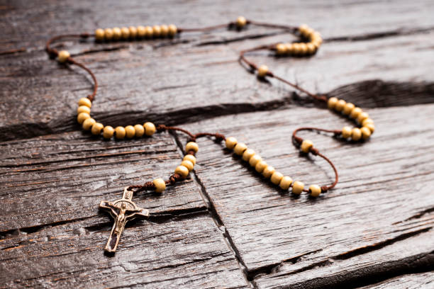 istock Holy catholic rosary and a cross - wooden background 1942847122