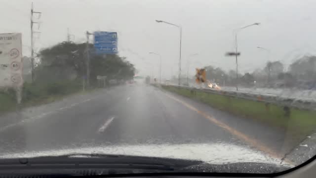Driving under the torrential rain during a tropical storm with sunlight