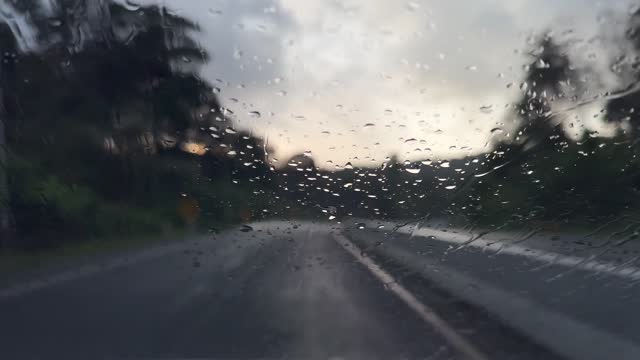 Driving under the torrential rain during a tropical storm with sunlight
