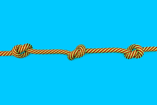 istock Multicolored rope with three knots on a blue background 1942899083