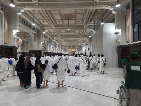 Umrah pilgrims circumambulate the Kaaba in the Grand Mosque, Alharam mosque, the most important holy place for Muslims, men are wearing white umrah clothes