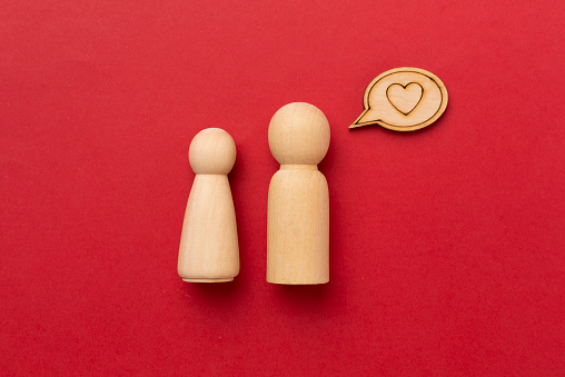 Wooden couple in love on color background, top view. Creative valentine's day composition