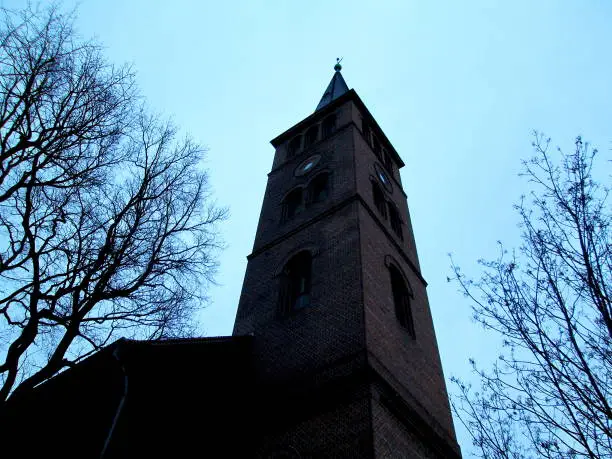 Berlin Koepenick Old Town Winter Cloudy Twilight Evangelical Church Tower with Bare Trees Silhouettes