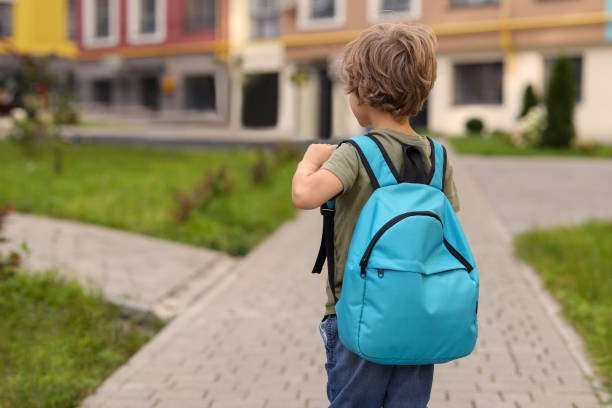 istock Little boy walking to kindergarten outdoors, back view. Space for text 1942941184