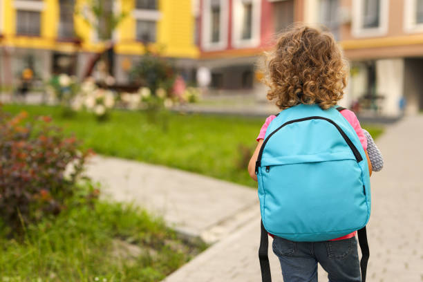 istock Little girl walking to kindergarten outdoors, back view. Space for text 1942941186