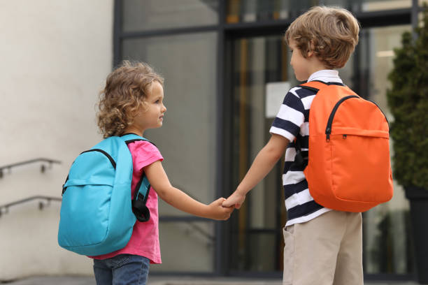 istock Brother and sister walking to kindergarten outdoors, back view 1942942065