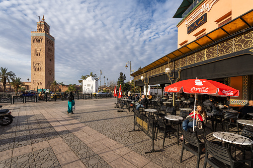 Marrakesh, Morocco - January 6, 2024: A street cafe in the center of Marrakech. Minaret de la Koutoubia in the background\n​