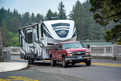 An RVer towing a 5th wheel trailer across the bridge entering Florence, Oregon during the summer. Florence, Oregon, is a popular travel destination with RVers.