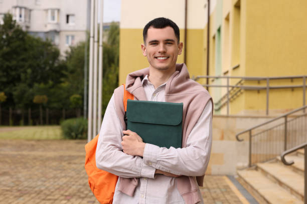 istock Happy young student with backpack and tablet outdoors 1942945073
