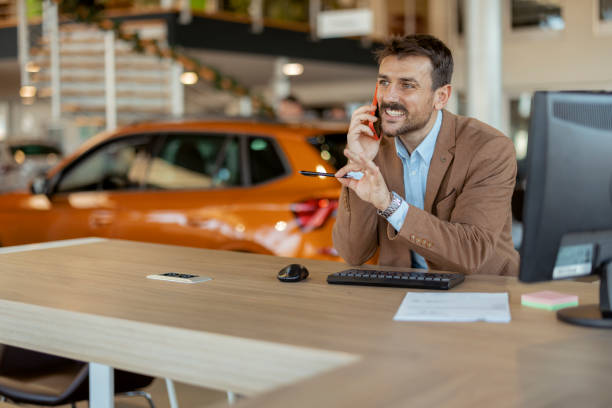 istock Car Dealer Talking on Mobile Phone 1942957439