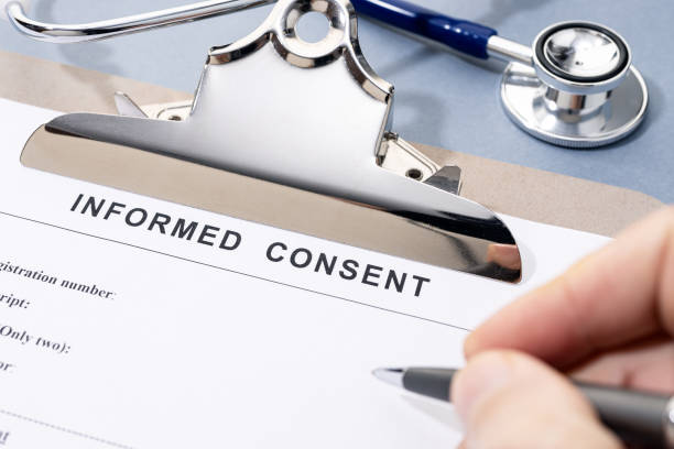 istock Hand filling a Informed Consent form on desk 1943009396