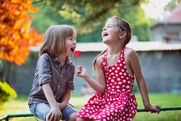 幸せな小さな男の子と女の子とロリポップ - child valentines day candy eating ストックフォトと画像
