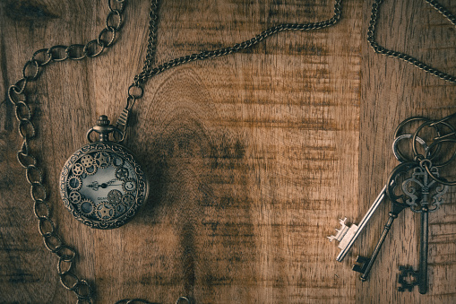 Flat lay background style image featuring a rustic look with a pocket watch and vintage keys
