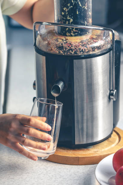 istock A woman makes apple juice at home with a juicer. 1943024485