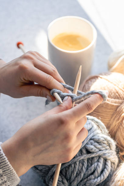 istock A woman knits with gray thread, close-up. 1943024572