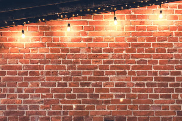 istock Lights garlands hanging from red brick wall at evening. 1943027544