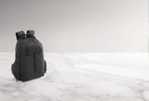 Black back pack on a white marble countertop