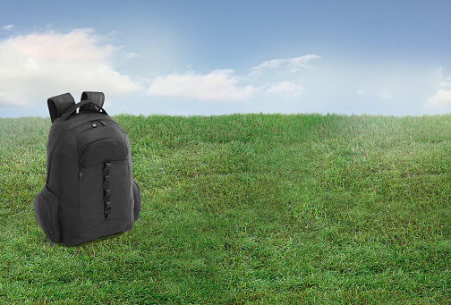 Black back pack on a grass lawn background