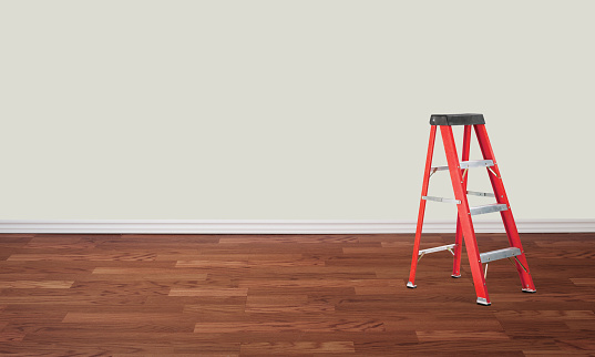 Metal ladder in an empty room with hardwood floor