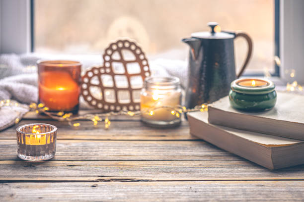istock Cozy background with books, candles and teapot by the window. 1943033893