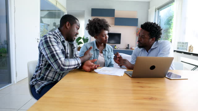 Black couple in a meeting with their financial advisor paying attention while discussing something and looking at documents