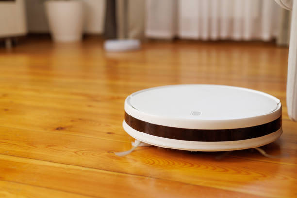 istock Automated Robotic Vacuum Cleaner on Wooden Floor 1943065392