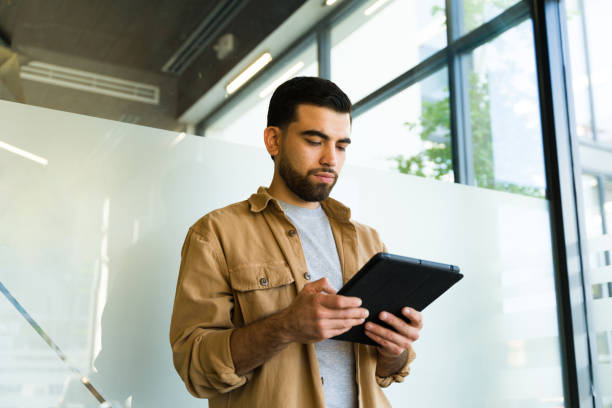 istock Young businessman in casual clothing using a tablet computer for work 1943092063
