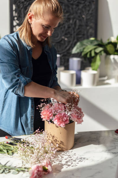 istock Female hands working with flowers 1943109873