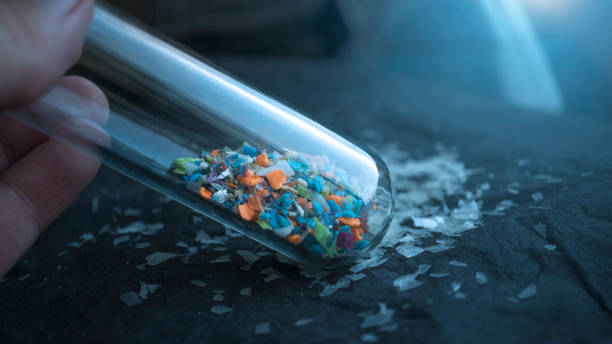 Microplastics inside a glass lab test tube. Concept of plastic pollution and industrial waste management. microplastic stock pictures, royalty-free photos & images