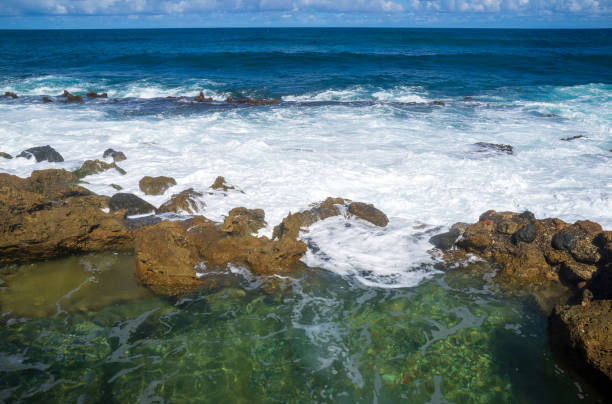 A beach at La Perla village, Old San Juan, Puerto Rico. Wave is coming and hitting to a rock, a natural phenomenon of the Earth movement. Good for background ideas or ecological, environmental subject