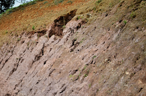 Underground soil layer of cross-section earth with grass on the top with hills view background