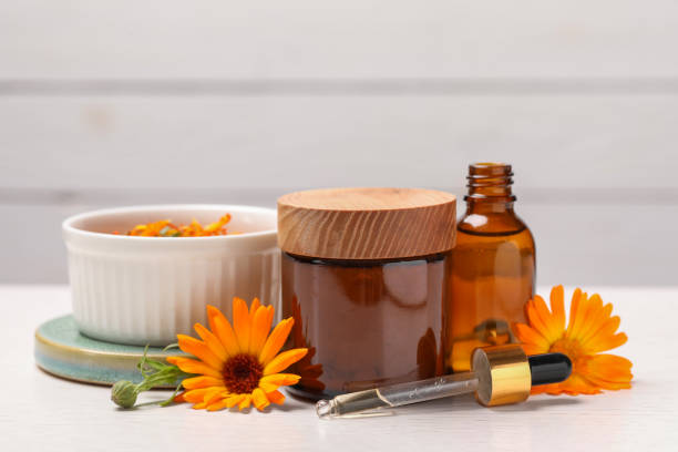 istock Different cosmetic products with beautiful calendula flowers on white table 1943136508