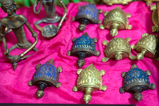 Metal turtle with coins in close-up. Golden background.