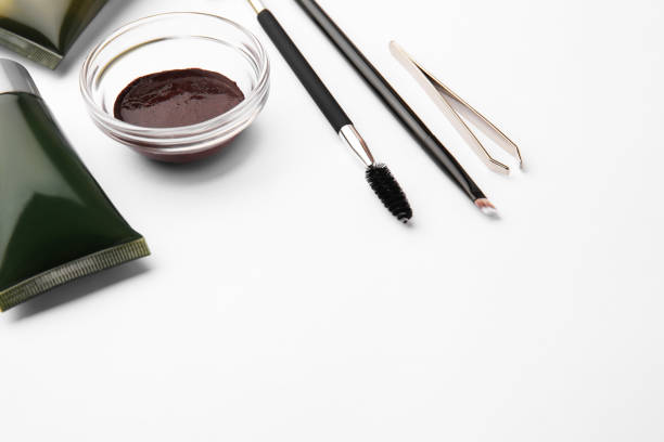 Eyebrow henna, professional tools and cosmetic products on white background, space for text