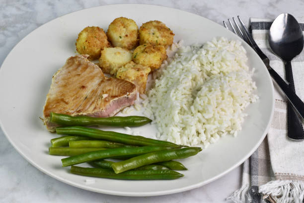 istock tuna steak served with scallops , rice and green beans, 1943164597
