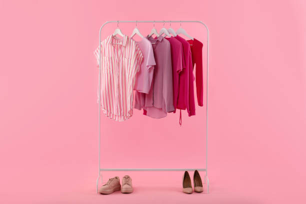 istock Rack with different stylish women's clothes and shoes on pink background 1943201760