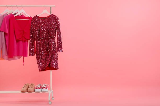 istock Rack with different stylish women`s clothes and sneakers on pink background, space for text 1943202269