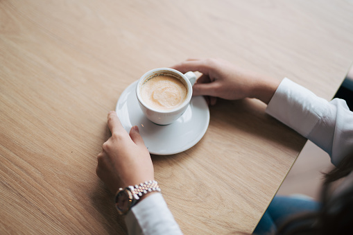 Lady's hands holding coffee cup