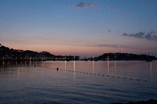 Baiona at dusk seen from Santa Marta with its houses, the sea and the Monterreal fortress in the background