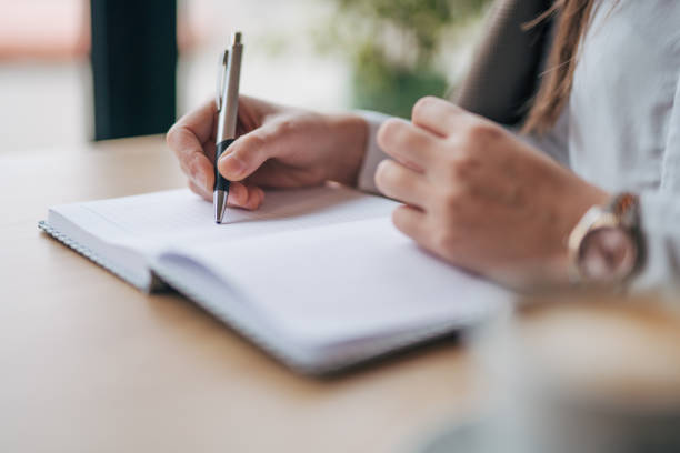 istock Young woman writing notes in the cafe 1943252236