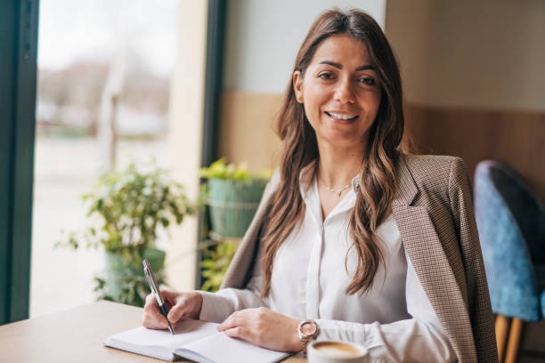 istock Young woman writing notes in the cafe 1943258474