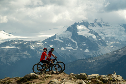 Mountain bikers pause on top of mountain before their descent