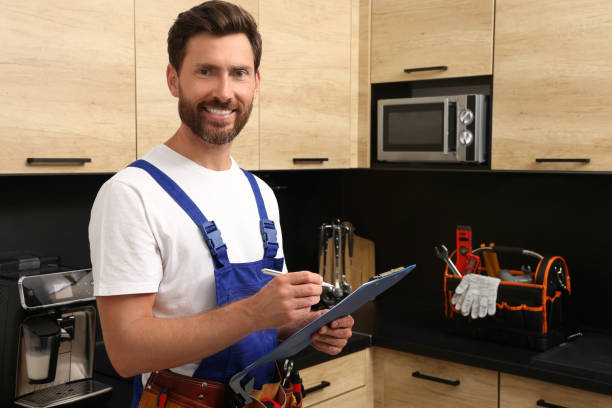 istock Professional plumber with clipboard and tool belt in kitchen 1943278922