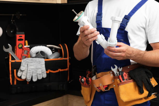 istock Professional plumber with corrugated pipe and tool belt indoors, closeup 1943280525