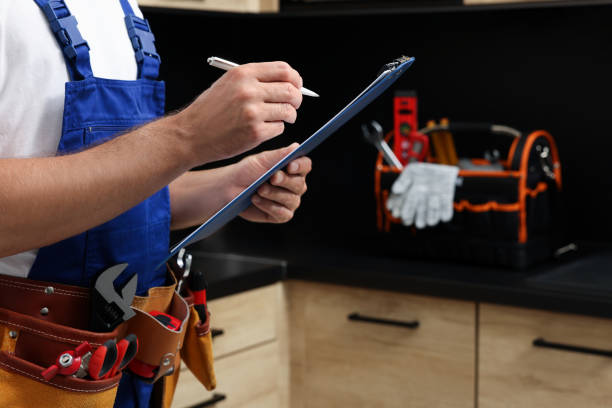 istock Professional plumber with clipboard and tool belt indoors, closeup. Space for text 1943281053