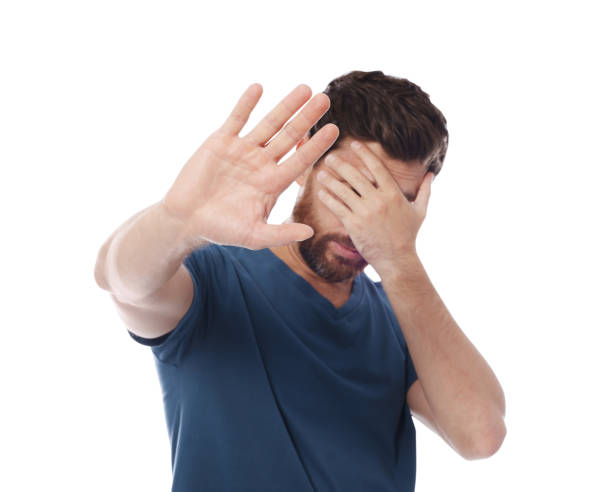 istock Embarrassed man covering face with hand on white background 1943282176